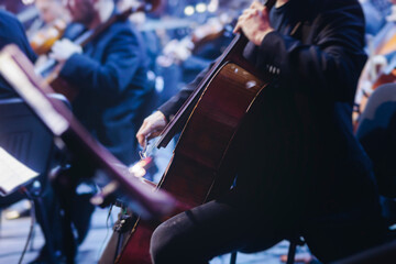 Concert view of contrabass violoncello player with vocalist and musical band during string concert, jazz orchestra performing music, violoncellist cello jazz player on stage in club, music arena hall