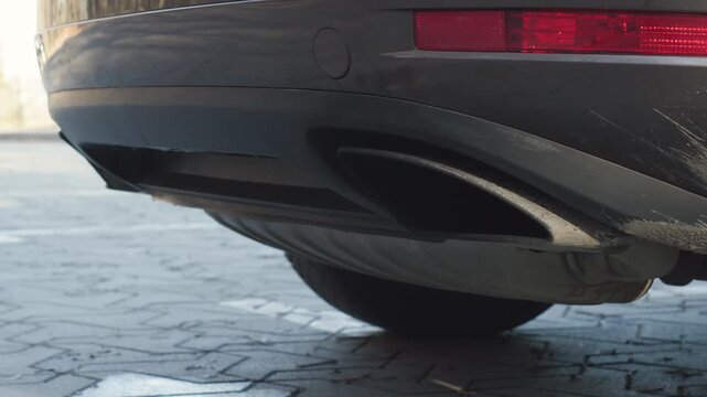 Diesel car exhaust close up as v6 engine starts with deep idle rumble and clean original sound, rear bumper detail outdoors