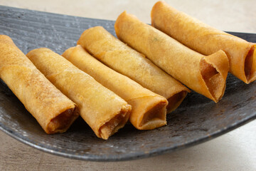 A closeup view of a plate of lumpia.