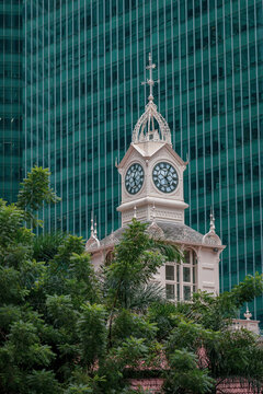 Clock tower on Lau Pa Sat Hawker Center Telok Ayer Market in Singapore with a building in the background