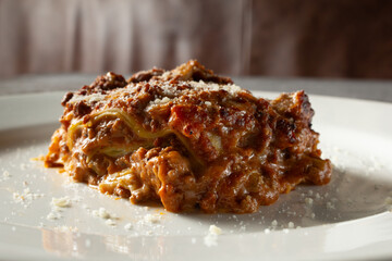 A closeup view of a lasagna, on a plate.