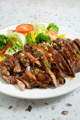 A view of a plate of beef and chicken teriyaki.