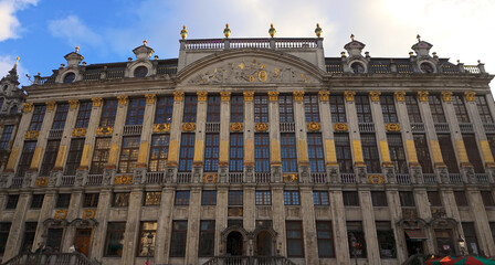 Naklejka premium BRUSSELS, BELGIUM - NOVEMBER 26, 2025 - Historic Grote Markt building showcasing elaborate architecture with golden details under a blue sky