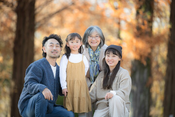 Autumn Family Photos: Smiling Three-Generation Family Portraits in a Forest of Autumn Leaves Commemorative Photos of Parents, Children, and Grandmother Camera-Ready Memorable Images　