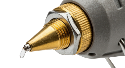 Close-up of a gold and silver precision nozzle with a small droplet of liquid falling