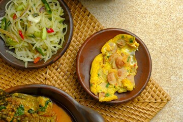 Indonesian food for lunch or dinner. Sausage omelette, stir-fried sprout beans and fish curry. Food background, menu book, recipe