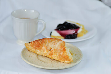 puff pastry , tart or pie with pineapple sauce stuffed and hot tea served with cheesecake