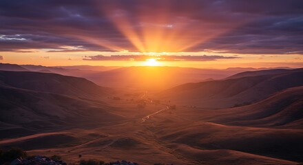 Scenic landscape with majestic sunrise bursting over distant rolling hills and a valley road