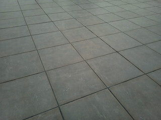 Top view of exterior ceramic floor with concrete or gray cement effect. Non-slip grey matte square terrace and porch porcelain stoneware tiles texture or background.