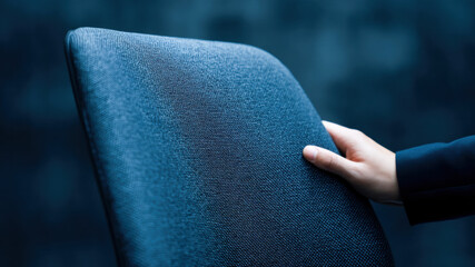 Modern office chair backrest texture with hand, business workspace detail, ergonomic design for work space comfort and focus in contemporary setting