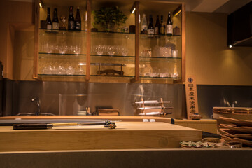 A cozy Japanese-style kitchen with sushi tools, ceramic dishes, and sake bottles, capturing the authentic ambiance of traditional culinary space.