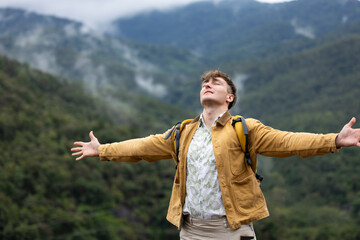 Man breathing deeply and embracing nature on eco trip