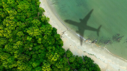 Aerial view of shadow passenger plane silhouette and sandy beach blue sea with waves at sea beach summer vacation sea travel concept