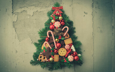 Festive christmas tree shaped wreath decorated with candies and cookies