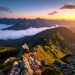Scenic mountain range at dawn, with clouds in the valley and the sun's warm glow on the peaks