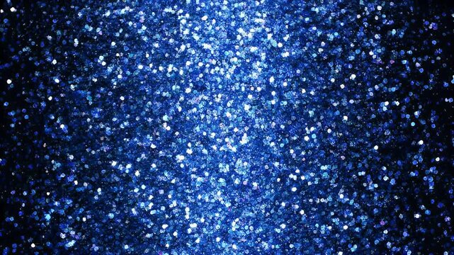 An image of blue glitter particles on a black backdrop