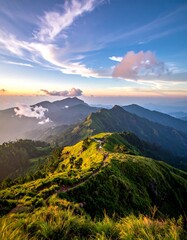 Scenic mountain ridge view at dusk, with sunlit grass and cloudy sky