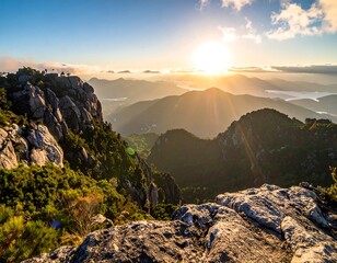 Scenic mountain vista captures golden sunrise, illuminating rugged peaks and valleys with warm light