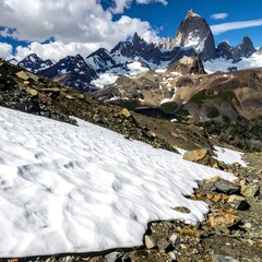 Scenic mountain vista showcasing snow-dusted slopes, rocky terrain, and majestic, snow-capped peaks