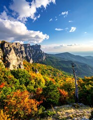 Scenic mountain vista showcasing vibrant autumn foliage and a bright, cloudy sky