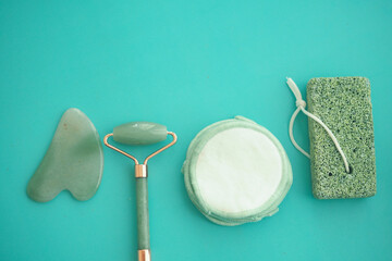 Beauty tools on a teal background for skincare routine