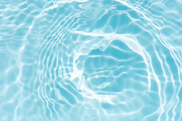 Blue water with ripples on the surface. Defocus blurred transparent blue colored clear calm water surface texture with splashes and bubbles. Water waves with shining pattern texture background.