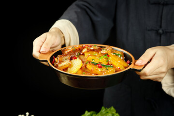 Chef Holding Spicy Chinese Pork and Potato Stir-Fry in Wok