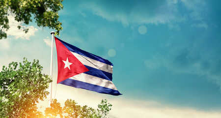 Cuba national flag waving in the sky behind the tree. The flag blowing with beautiful sunlight. Cuba national flag for independence day.