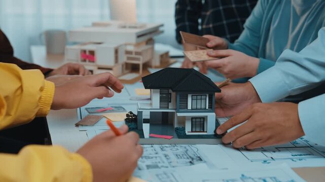 A vibrant office scene showcasing a diverse group actively collaborating on an architecture model, emphasizing teamwork and creative processes in design and planning initiatives. SACTR