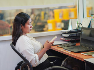 Businesswoman using phone laptop browsing internet goal planning new beginnings remote work workplace. Young professionals meeting collaboration brainstorming in office. Female leadership use AI chat