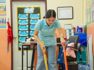 Asian teacher woman cleaning classroom at school. People clean housework college. Back to school. Education knowledge learning. Chore of student 