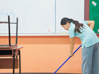 Asian teacher woman cleaning classroom at school. People clean housework college. Back to school. Education knowledge learning. Chore of student 