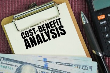 Pen, paper money and calculator with the words Cost-Benefit Analysis CBA is a systematic process for evaluating the pros and cons of a project or decision by comparing its total expected costs again