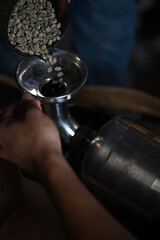 Adding coffee beans to the jar for roasting.
