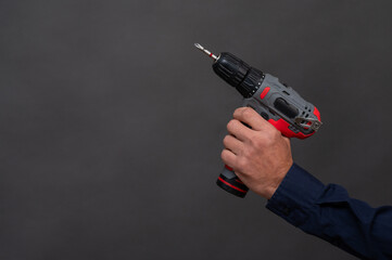 a cordless screwdriver in a man's hand, close-up