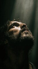 Contemplative Man: A close-up of a man's face, bathed in a dramatic light. His eyes are directed upwards in a moment of introspection.