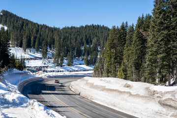 Scenic view of the road with snow and mountain background in winter season, sunny day