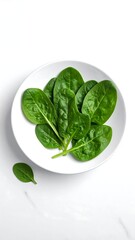 Close-up shot of vibrant green leafy vegetables arranged in a white circular bowl against a marble background. One leaf is separate