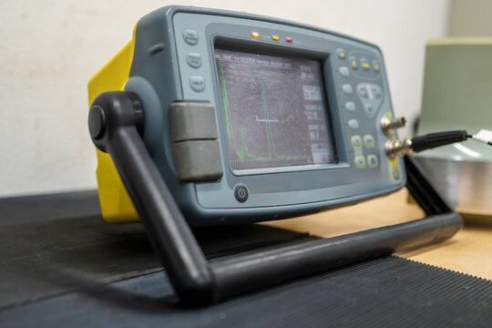 Portable ultrasonic flaw detector with digital display screen showing waveform data for non-destructive testing and industrial material inspection quality control applications