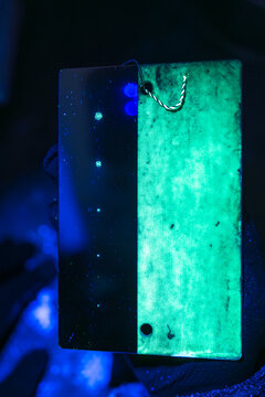 Fluorescent penetrant inspection TAM panel under ultraviolet light, displaying test patterns for system performance verification and quality assurance in non-destructive testing applications