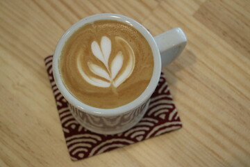 Latte Art in White Coffee Cup on Coaster