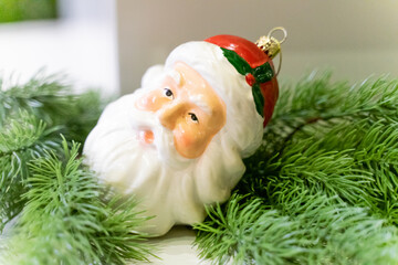 A charming Christmas setup featuring a Santa Claus figurine surrounded by small festive decorations and wrapped presents. The scene highlights warm holiday cheer with miniature ornaments, gift boxes, 