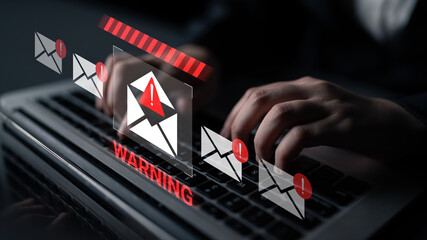 A close-up view of hands typing on a laptop with digital warning notifications highlighting email threats, emphasizing the importance of cybersecurity in today digital landscape. Gantry