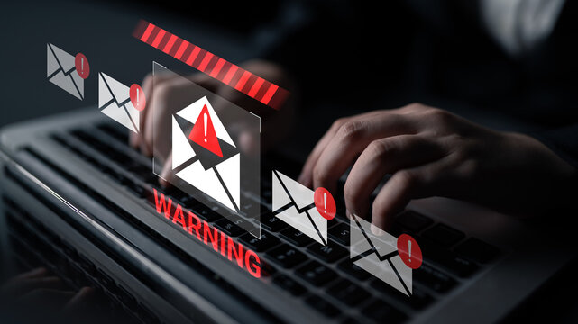 A close-up view of hands typing on a laptop with digital warning notifications highlighting email threats, emphasizing the importance of cybersecurity in today digital landscape. Gantry - Powered by Adobe