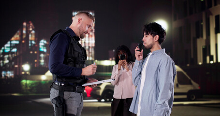 Police Officer Conducts Breathalyzer Test During Traffic Stop; Bystander