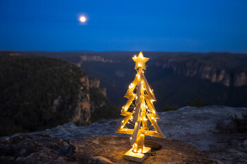 Christmas in the mountains.  Christmas in Blue Mountains with moon in the twilight sky and a deep valley and distant cliffs in background