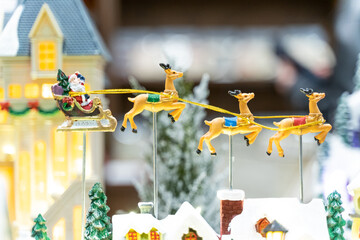 A beautifully crafted Christmas music box featuring reindeer, Santa figures, festive dolls, and a rotating carousel. The intricate design, warm lighting, and nostalgic holiday motifs create a magical 