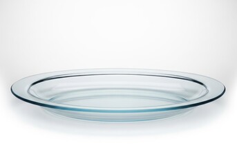 Clear circular glass baking dish rests horizontally on a white illuminated surface