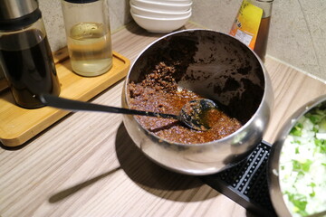 Taiwanese satay sauce in a stainless steel bowl, with a spoon.