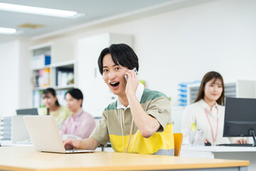 オフィスで電話をする若いエンジニア